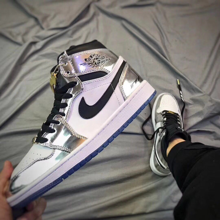 Close-up side view of a white and silver Jordan high-top sneaker with black Swoosh and blue outsole.