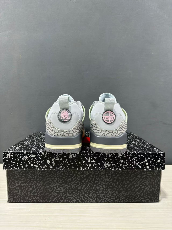 Rear view of grey and white Jordan Spizike Low sneakers showing elephant-print heel panels, dark grey midsoles, and pale yellow outsole accents.
