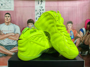 Angled view of the fluorescent green sneakers showing the high-top shape, sculpted side panels, heel structure, and patterned midsole section.