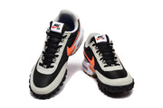 Top-front view of a pair of Nike Air Max Waffle SP sneakers with black uppers, gray overlays, and orange swooshes.
