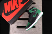 High-top sneaker displayed beside a branded shoe box, showing the black, green, and white color scheme.