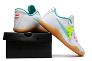 White and teal Kobe 11 shoes posed on a black shoe box