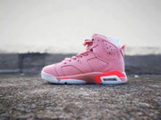 Opposite side view of the pink Air Jordan 6 high-top sneaker showing its laces, perforated upper, and heel cushioning window.