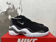 Side view of black Nike sneakers showing grey patterned panels and a white sole.