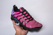 Pink, black, and blue Nike sneakers shown from a front three-quarter angle.