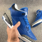 Close side view showing the blue upper, perforated collar panel, laces, and elephant-print trim.
