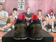 Rear view of the sneakers showing olive heel panels, black collars, and red signature-style details.