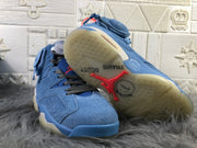 Pair of sky blue Jordan 6 sneakers shown from below, highlighting the translucent outsole and red accents.