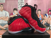 Angled side view showing the glossy red upper, black collar and laces, pull tabs, and translucent outsole.