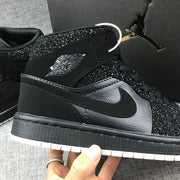 Close-up of the black side panel, Swoosh and winged basketball branding with speckled overlays.
