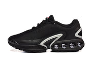 Side view of a black Nike sneaker with light-colored accents and heel cushioning pods