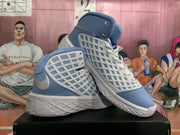 Angled side view showing the Carolina blue upper, white grid-patterned panels, metallic silver accent, and textured white outsole.