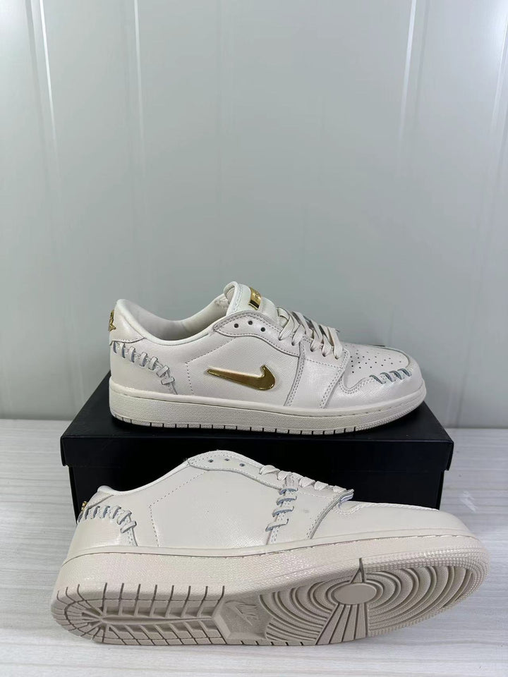 White and gold low-top sneakers shown from the side and outsole.