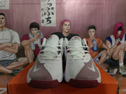 Front view of white Nike basketball sneakers showing the laces, tongue branding, mesh panels, and red outsole.