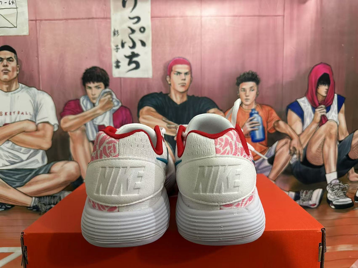 Rear view of white Nike shoes with pink patterned heel panels and red collar lining.