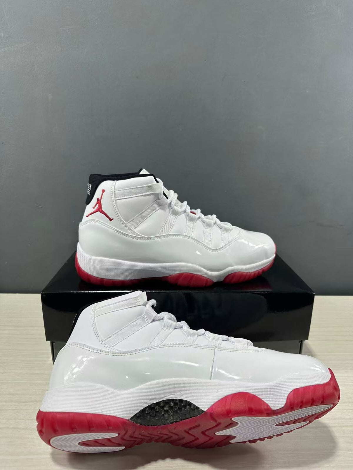 White and red Jordan Air Jordan 11 Retro Low sneakers shown from the side and outsole angles.