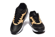 Top view of a pair of black and tan Nike Air Max sneakers.