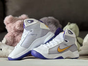 Angled view of two white high-top sneakers showing the purple collars, purple outsoles, and side branding.