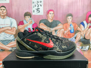 Side view of black, olive, and red camouflage Nike basketball sneakers displayed on a black shoebox.