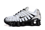 Side view of a white Nike Shox TL sneaker with silver overlays, black accents, and a sculpted black sole.