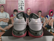 Rear view of pink and light-colored Nike basketball sneakers on a box, showing layered heel detailing and dark collar padding.
