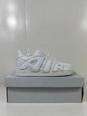 Side profile of a white low-top sneaker displayed on a gray shoebox.