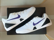 Pair of white Nike Kobe 9 sneakers shown at an angle with purple Swooshes and black speckled side accents.