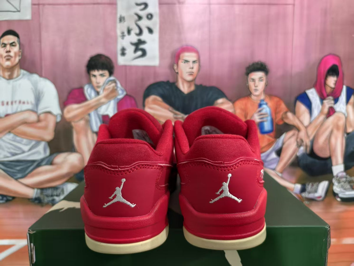 Rear view of red low-top sneakers with matching heel panels, Jumpman emblems, and cream-colored outsole sections.