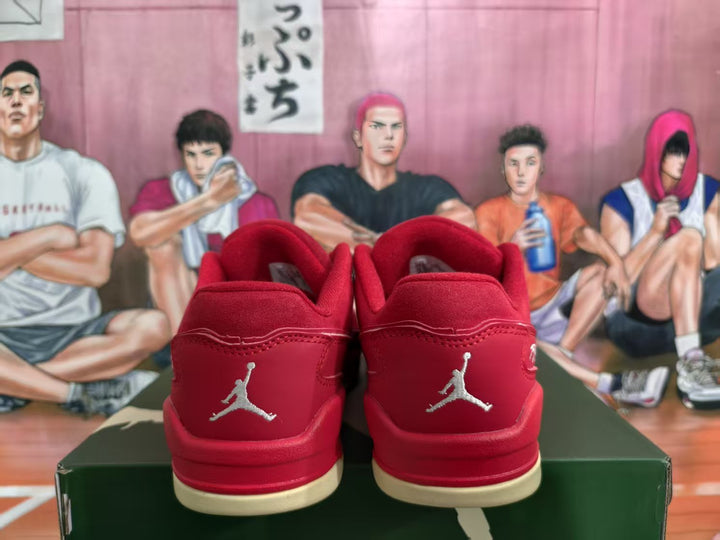 Rear view of red low-top sneakers with matching heel panels, Jumpman emblems, and cream-colored outsole sections.