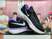 Angled view of black Nike basketball shoes with white Swoosh logos and purple details