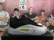 Side profile of a black and white Jordan basketball sneaker with a white midsole and red side logo.