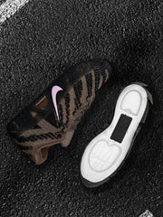 Top and outsole views of the brown and black Nike sneakers with pink Swoosh branding.