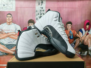 Pair of white and navy Jordan high-top basketball sneakers shown from the side and outsole angles on a shoe box.