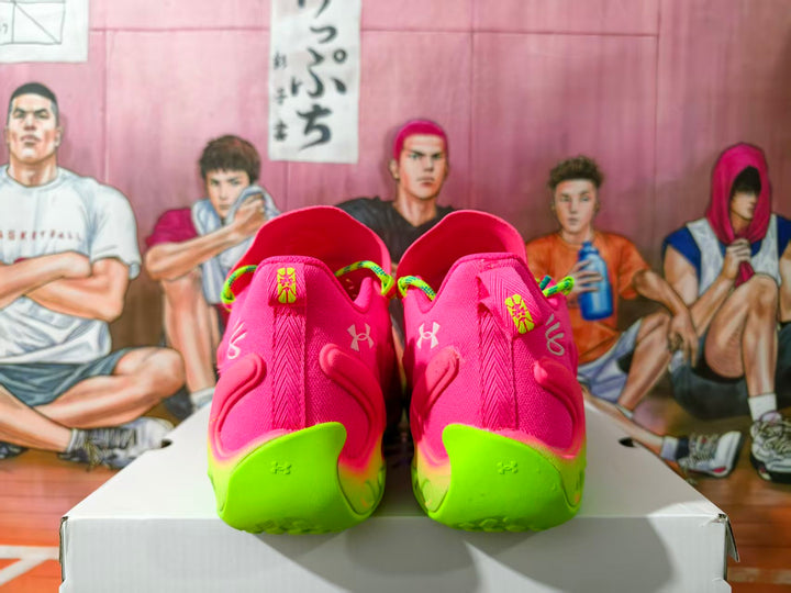 Rear view of pink Under Armour sneakers with neon green heel sections.