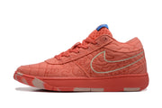 Side profile of a coral low-top sneaker showing the patterned upper, lace eyelets, silver outlined swoosh, and flat rubber sole.