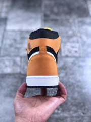 Rear view of one sneaker showing the orange heel, black collar, white midsole, and black outsole.