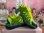 Angled view of green and yellow basketball sneakers showing side details and outsole