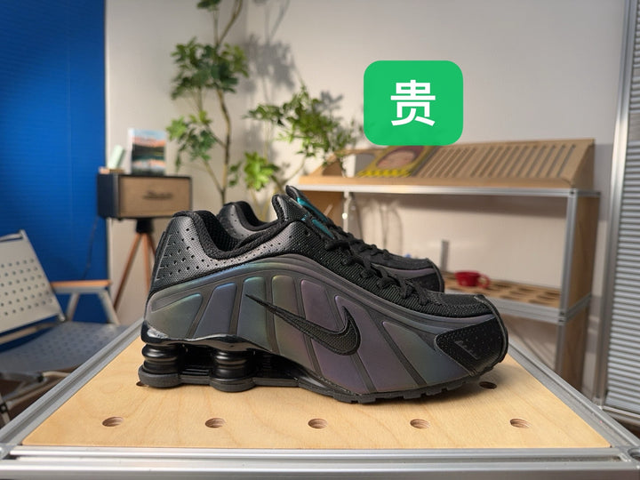 Black Nike Shox-style sneaker with iridescent side panels and sculpted heel cushioning, shown from the side.