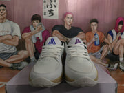Front view of white basketball sneakers with blue JA tongue branding and tan speckled soles.