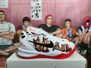 Side profile of a white Nike basketball sneaker with a black Swoosh, horse graphics, red outsole, and padded collar.