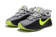 Pair of smoke grey and black sneakers with neon yellow-green outsole details.