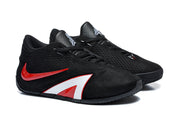 Angled view of the black lace-up sneakers with red and white details