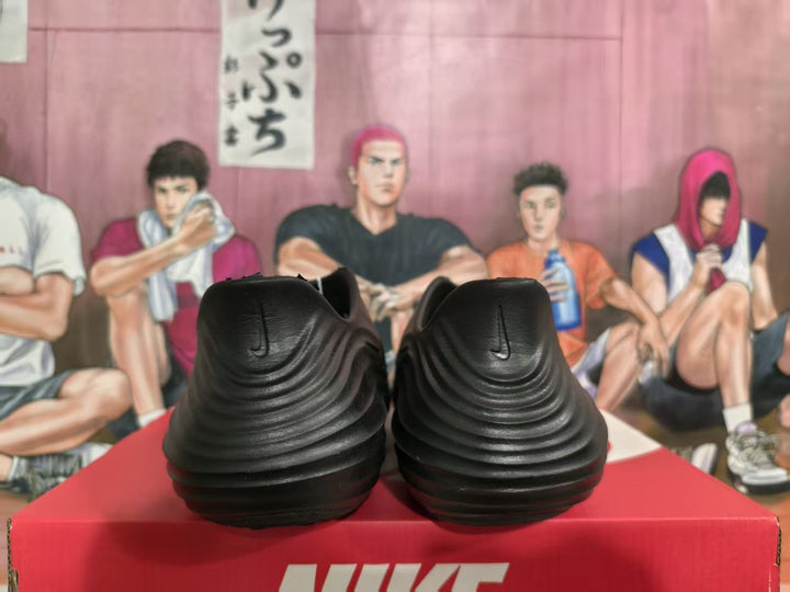 Rear view of black Nike sneakers showing layered heel detailing and Nike logos, displayed on a red Nike shoebox.