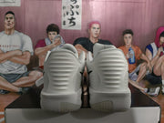 Rear view of the white Nike sneakers showing the ridged heel panels and segmented outsole.