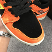 Detailed view of the black laces, perforated toe box, and orange trim.