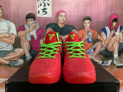Front view of red basketball sneakers with bright green laces, green tongue accents, and textured uppers.