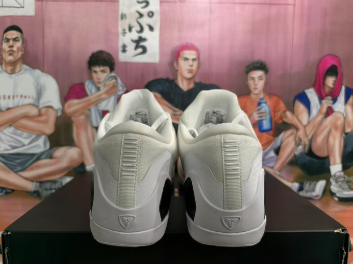 Rear view of a white pair of Nike basketball sneakers showing padded collars, heel details, and black midsole sections.