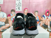 Rear view of the pair showing glossy black heel panels, red signature-style details, padded collars, and gray midsoles.