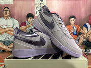 Two gray and purple low-top sneakers shown from the side