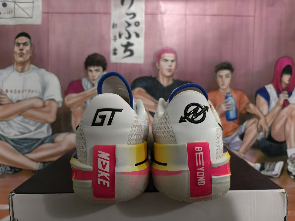 Rear view of white and gray Nike GT sneakers showing GT heel marks, blue collars, and pink and yellow heel accents.